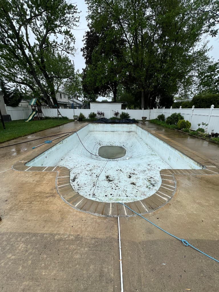After: swim-ready water with mesh safety fencing, patterned paver surround, and integrated spa zone aligned with circulation work.